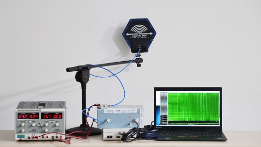 EMC testing bench with Aaronia antenna, spectrum analyzer, and target laptop